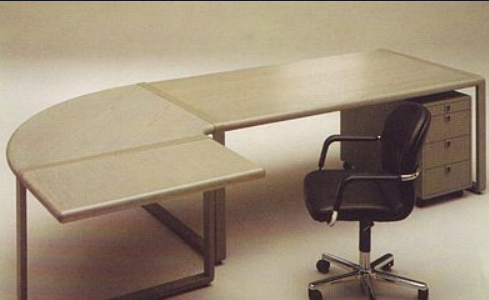 1982 Schreibtisch-Design L-förmiger Schreibtisch mit Schubladen und einem Drehstuhl auf Rollen.